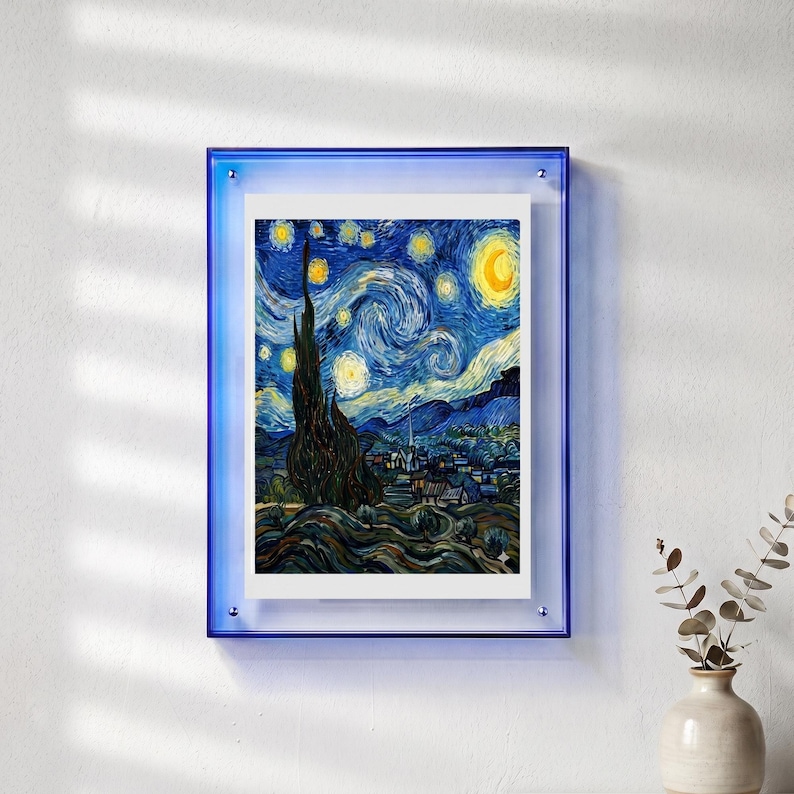 Peut inclure: Une impression encadr&eacute;e de l'&oelig;uvre "La Nuit &eacute;toil&eacute;e" de Van Gogh. L'impression est pr&eacute;sent&eacute;e dans un cadre en acrylique bleu, mont&eacute;e sur un mur blanc. L'&oelig;uvre pr&eacute;sente un ciel nocturne tourbillonnant avec des &eacute;toiles jaunes et un croissant de lune.