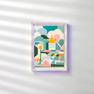 Peut inclure: Une impression d'art encadr&eacute;e repr&eacute;sentant un paysage abstrait avec une maison, des arbres et des formes g&eacute;om&eacute;triques. L'&oelig;uvre utilise une palette de couleurs turquoise, bleu, jaune, rose et orange. L'impression est dans un cadre en acrylique transparent.