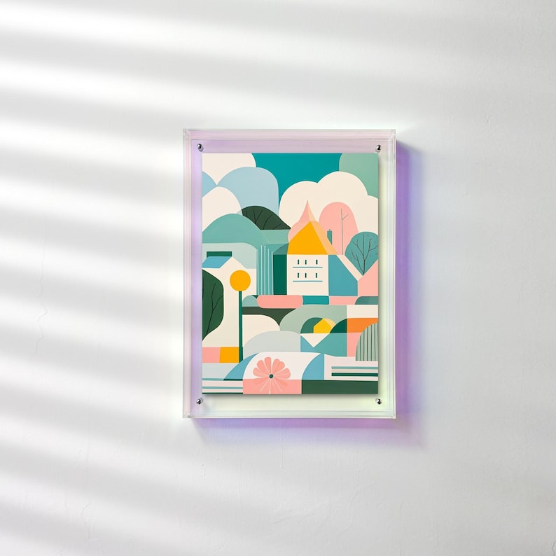 Peut inclure: Une impression d'art encadr&eacute;e repr&eacute;sentant un paysage abstrait avec une maison, des arbres et des formes g&eacute;om&eacute;triques. L'&oelig;uvre utilise une palette de couleurs turquoise, bleu, jaune, rose et orange. L'impression est dans un cadre en acrylique transparent.