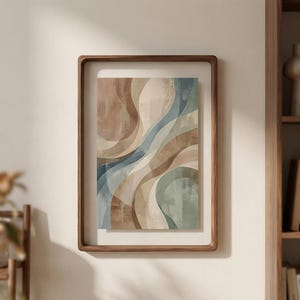 Puede incluir: Impresión artística abstracta en un marco de madera. La obra presenta formas fluidas y superpuestas en tonos marrón, beige y azul verdoso. El marco es de un tono de madera cálido y natural, añadiendo un toque de elegancia.