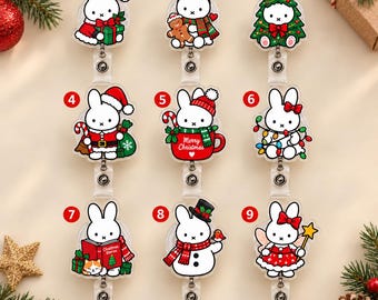 Puede incluir: Nueve portatarjetas de acrílico con un conejo blanco en varios temas navideños, incluyendo un traje de Santa, astas de reno, un árbol de Navidad, una taza con el texto Merry Christmas, luces, un libro, un muñeco de nieve y un hada.