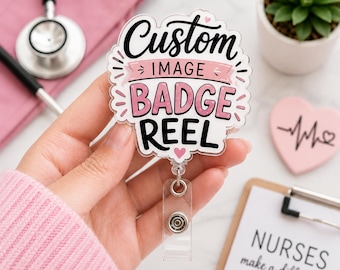 Könnte beinhalten: Ein transparenter Ausweishalter aus Acryl mit dem schwarzen Schriftzug Custom, dem rosa Bannertext IMAGE und dem schwarzen Text BADGE REEL. Das Design enthält kleine rosa Herzen und dekorative Linien sowie eine einziehbare Schnur mit Kunststoffclip.