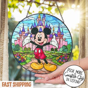 Puede incluir: Atrapasoles redondo de vidriera con Mickey Mouse frente a un castillo. La obra de arte tiene un borde negro y está suspendida por una cadena. La imagen incluye el texto "Pick More Suncatcher Style in Listing!"