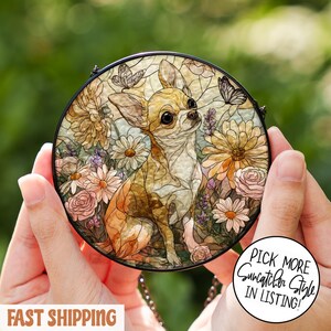 May include: Round stained glass suncatcher featuring a Chihuahua dog surrounded by flowers and butterflies. The artwork has a black border and is held by hands. The text "Pick More Suncatcher Style In Listing!" is visible.