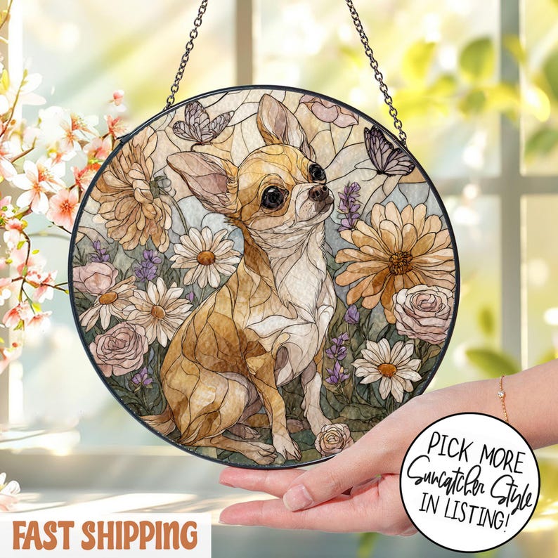 May include: Round stained glass suncatcher featuring a Chihuahua dog surrounded by flowers and butterflies. The artwork has a brown, tan, and white color palette with a black border and hanging chain. The text "Pick More Suncatcher Style In Listing!" is in a white circle.