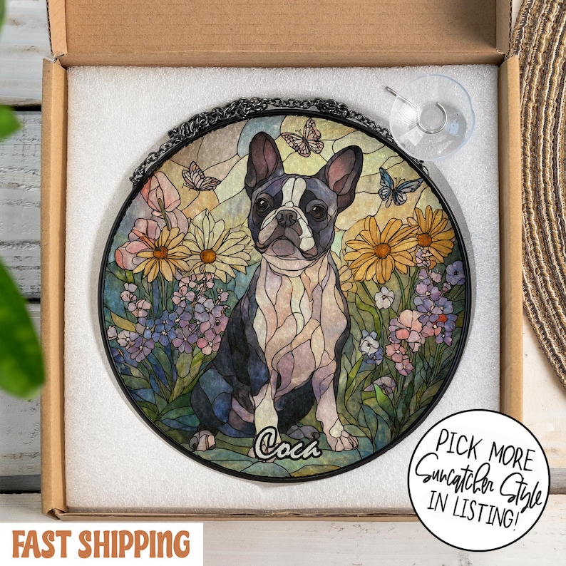 May include: Round stained glass suncatcher featuring a Boston Terrier dog in a garden setting with flowers and butterflies. The dog is black and white, with the name "Coca" at the bottom. Includes a hanging chain and suction cup.