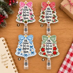 May include: Four bell-shaped badge reels featuring the text Oh come let us ADORE Him. One has a pink bow and hearts, one a red plaid bow with ornaments, one a blue bow with snowflakes, and one a green bow with poinsettias and holly berries.