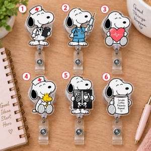 Peut inclure: Six enrouleurs de badge Snoopy sur le thème médical. Les motifs incluent Snoopy en infirmier, en médecin avec une seringue, tenant un cœur, avec Woodstock, tenant une radiographie et tenant un mug avec le texte Scrubs Coffee Patients Repeat.