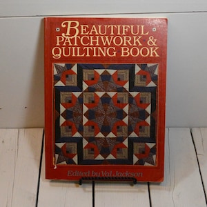 May include: A red book titled "Beautiful Patchwork & Quilting Book" with a colorful quilt pattern on the cover. The book is edited by Val Jackson.