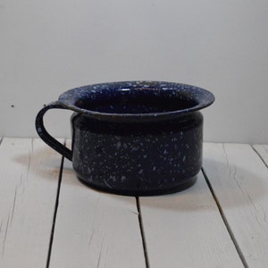 May include: A blue and white speckled enamel chamber pot with a handle.