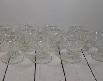 May include: Set of ten clear glass dessert dishes with a textured, diamond-like pattern. The dishes have a footed base.