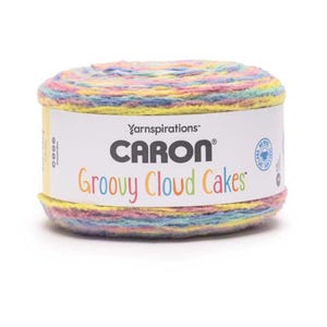Puede incluir: Ovillo de lana Caron Groovy Cloud Cakes en tonos pastel, rosa, amarillo, azul y verde. La lana está envuelta alrededor de una etiqueta blanca con el nombre de la marca y del producto. Ideal para proyectos de punto y ganchillo. La lana tiene forma cilíndrica.