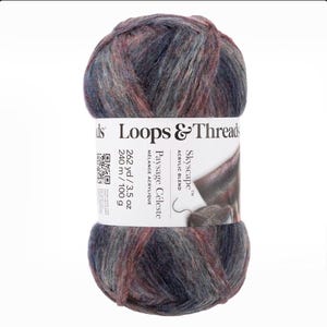 May include: A ball of Loops & Threads Skyscape acrylic blend yarn in shades of blue, grey, and burgundy. The label says "Paysage Céleste" and indicates 240 m / 100 g. Ideal for knitting and crochet, this yarn offers a blend of colours.