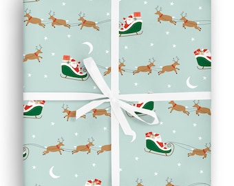 May include: Wrapped gift with light blue wrapping paper featuring a repeating pattern of Santa Claus in his sleigh pulled by reindeer, with stars and crescent moons. Tied with a white ribbon.