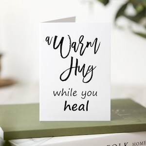 A white card with black text that reads 'a warm hug while you heal'.