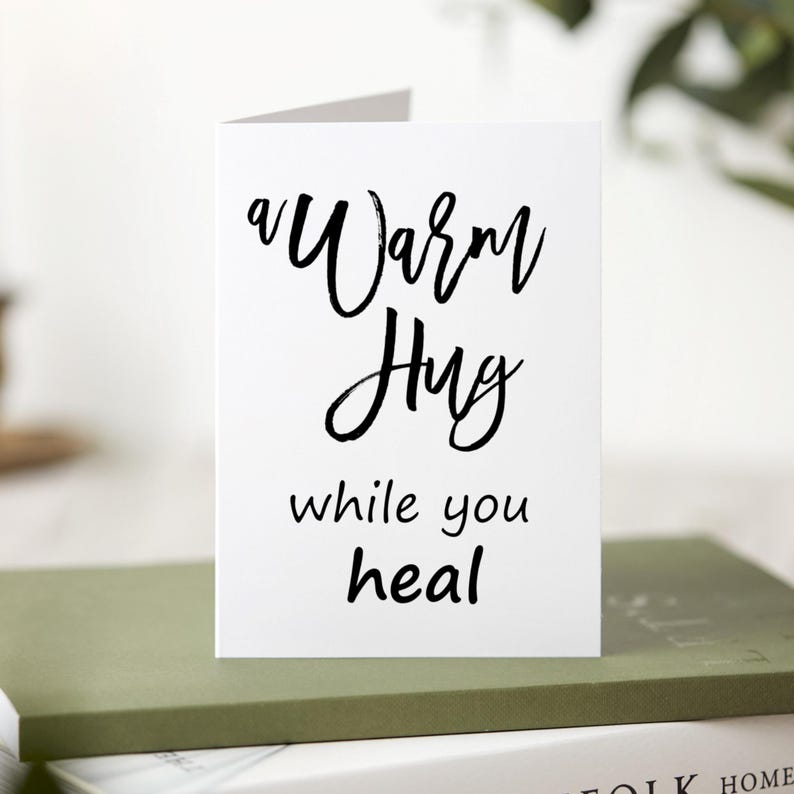 A white card with black text that reads 'a warm hug while you heal'.