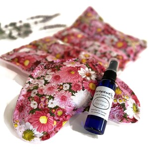 May include: Four floral print heat packs with a blue bottle of essential oil spray labeled "Aroma Therapy! Essential Oil Spritzer for comfort packs".