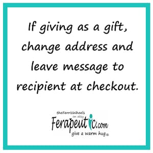 May include: A square sign with a teal border containing the black text: If giving as a gift, change address and leave message to recipient at checkout. Below this, the text reads: theFerrisWheels on etsy Ferapeutic.com give a warm hug.