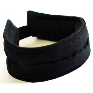 May include: Black padded headband with a thick, wide band and a narrower band on top. The headband is made of a soft, stretchy material.