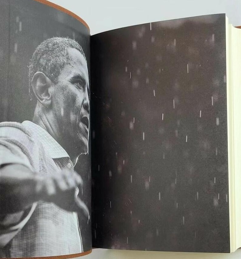 May include: A black and white photo of a man speaking in front of a crowd. The photo is grainy and has a rain-like effect.