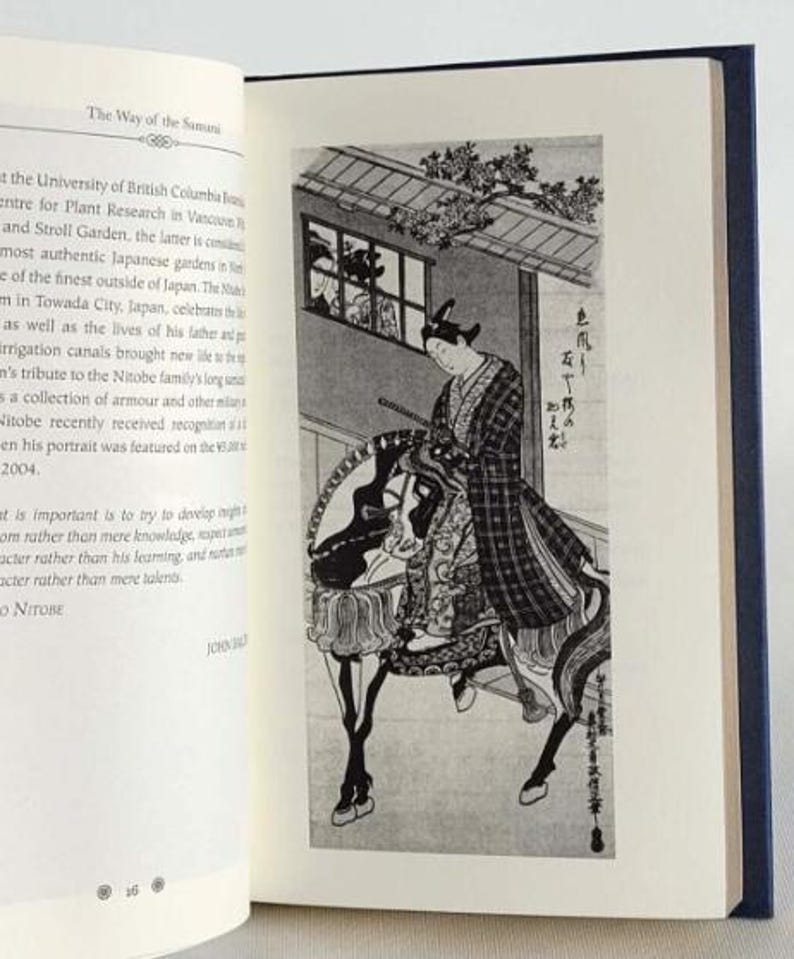 May include: A black and white illustration of a person riding a horse. The person is wearing a patterned robe and a hat. The illustration is set against a background of a building with a window and a tree.