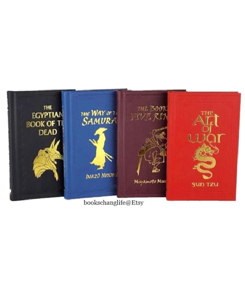 May include: Four small hardcover books with gold lettering and illustrations on the covers. The books are titled "The Egyptian Book of the Dead", "The Way of the Samurai", "The Book of Five Rings", and "The Art of War".