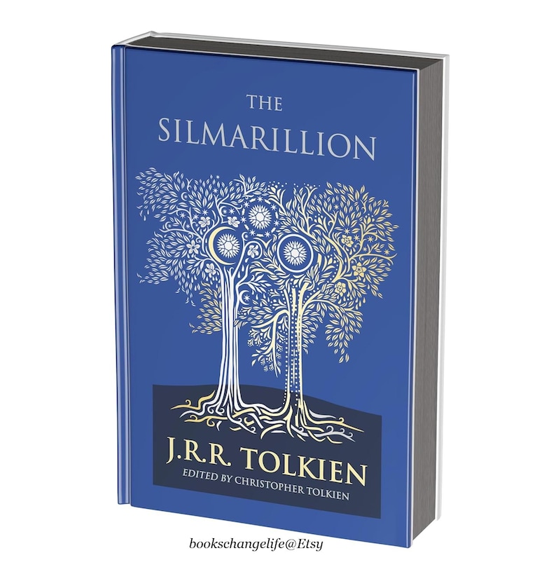 May include: The Silmarillion by J.R.R. Tolkien, a hardcover book with a blue cover featuring a gold illustration of two trees with intricate details. The title "The Silmarillion" is printed in gold lettering on the cover.