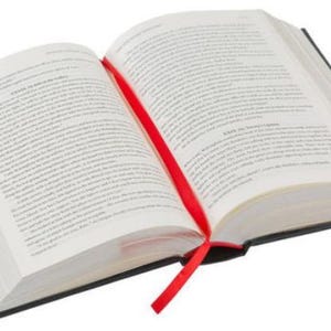 May include: A hardcover book with a red ribbon bookmark. The book is open to a page with text printed on it.