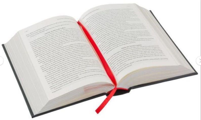 May include: A hardcover book with a red ribbon bookmark. The book is open to a page with text printed on it.