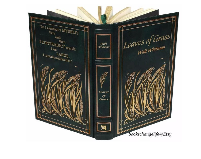 May include: A green leather-bound book with gold lettering titled "Leaves of Grass" by Walt Whitman. The cover features a gold illustration of blades of grass.