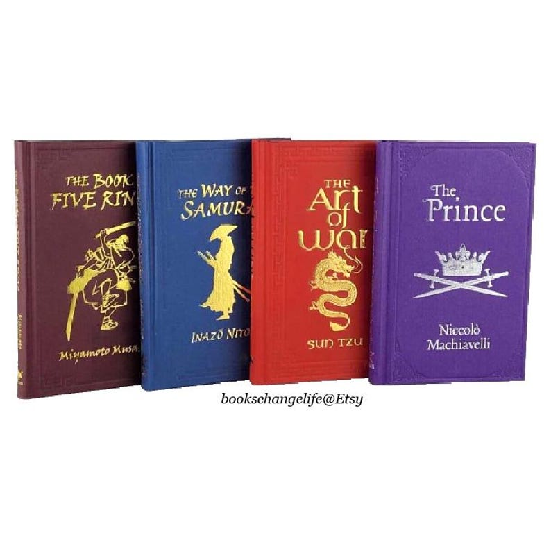 May include: Set of four hardback books with gold lettering and illustrations. The books are titled "The Book of Five Rings", "The Way of the Samurai", "The Art of War", and "The Prince".