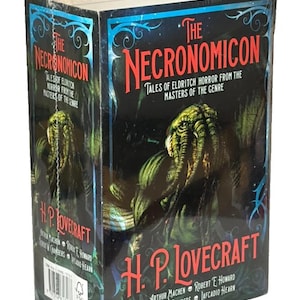 May include: A shrink-wrapped book titled "The Necronomicon" by H.P. Lovecraft. The cover features a green and black illustration of a monstrous figure. The title is in red, with the author's name prominently displayed.