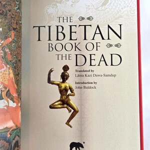 K&ouml;nnte beinhalten: Das Cover von "Das tibetische Totenbuch" zeigt eine goldene Statue einer tanzenden Frau. Der Titel ist in gro&szlig;en schwarzen Buchstaben gehalten, darunter die Namen des Autors und &Uuml;bersetzers. Das Arcturus-Logo befindet sich unten.