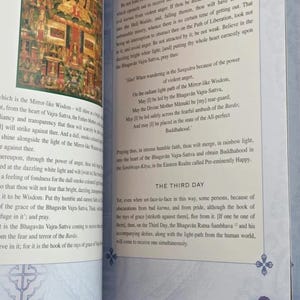 K&ouml;nnte beinhalten: Offenes Buch mit Text und einer Illustration einer sitzenden Figur. Der Text beschreibt den Weg zur Befreiung und die Macht des Bhagavan Vajra-Sattva. Die Seitenzahl ist 47.