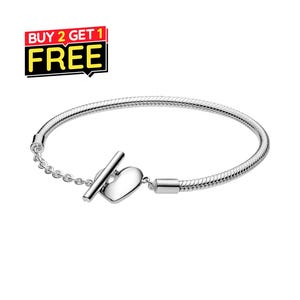 May include: A silver-toned snake chain bracelet featuring a toggle clasp with a heart-shaped charm and a short length of delicate link chain. The image includes a graphic label in the upper left corner with the text BUY 2 GET 1 FREE.