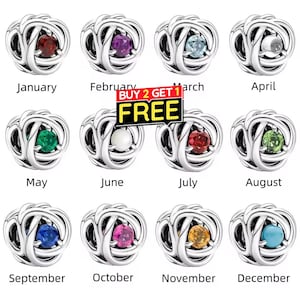 May include: A collection of silver-colored birthstone charms, each featuring a different colored gemstone. The charms are labeled with the months of the year, from January to December. A promotional banner reads "BUY 2 GET 1 FREE".