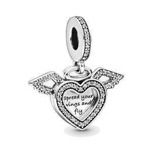 May include: A silver charm with a heart-shaped pendant and small wings. The heart is outlined with clear crystals and has the words "spread your wings and fly" engraved on it. The charm is designed to be attached to a bracelet or necklace.