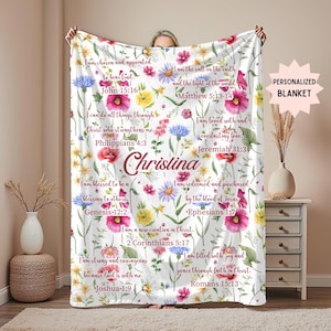 May include: White personalized blanket with a floral design and inspirational quotes. The blanket features colorful flowers and the name "Christina" in the centre. The text includes Bible verses.
