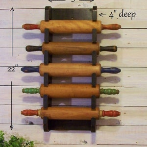 Peut inclure: Un porte-rouleaux en bois noir avec cinq rouleaux &agrave; p&acirc;tisserie en bois. Le support mesure 9 pouces de large et 4 pouces de profondeur. Le support est mont&eacute; sur un mur en bois blanc. Les rouleaux &agrave; p&acirc;tisserie mesurent 22 pouces de long.