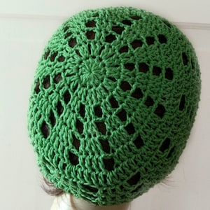 Peut inclure: Chapeau crocheté vert avec un motif ajouré. Le chapeau est réalisé en point de crochet simple et a une forme circulaire.