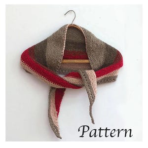 May include: A knitted shawl in shades of brown, red, and beige, displayed on a wooden hanger. The shawl features a striped pattern and is made of a soft, textured yarn. The word "Pattern" is written in black script at the bottom.