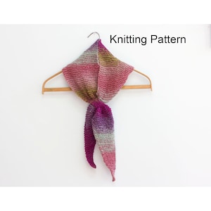 May include: A knitted scarf with a gradient of pink, purple and green colours. The scarf is tied in a knot and draped over a wooden hanger. The text "Knitting Pattern" is visible in the top right corner of the image.