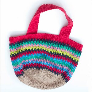 May include: A colorful crocheted tote bag with red handles and a striped pattern in shades of blue, green, pink, and black. The bottom of the bag is a solid brown color.