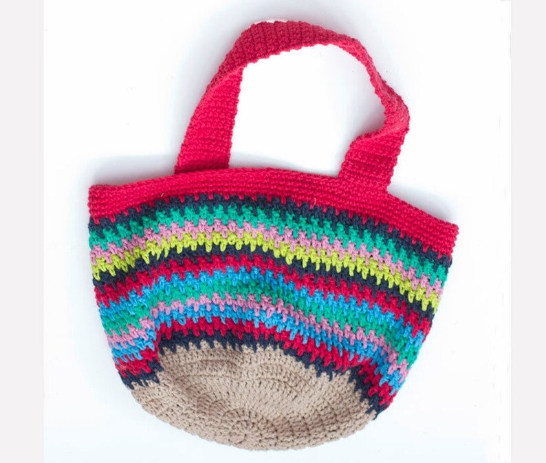 May include: A colorful crocheted tote bag with red handles and a striped pattern in shades of blue, green, pink, and black. The bottom of the bag is a solid brown color.