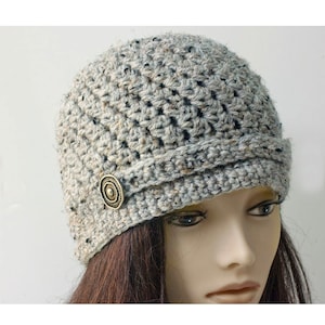 May include: A gray crocheted beanie with a decorative button on the side.