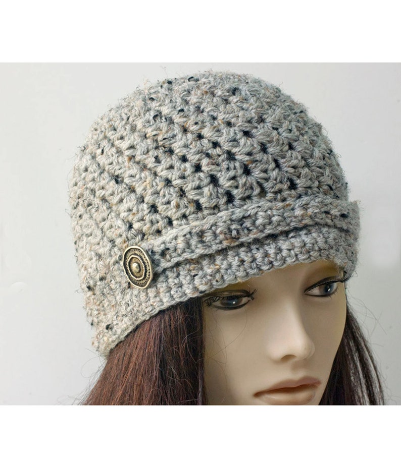 May include: A gray crocheted beanie with a decorative button on the side.