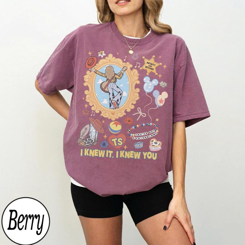 May include: A berry-colored t-shirt featuring a graphic print of a person in a mirror frame, a sheriff badge with the text INFINITY AND BEYOND, balloons, a beaded bracelet with the text YOU'VE GOT A FRIEND IN ME, and the text I KNEW IT, I KNEW YOU.