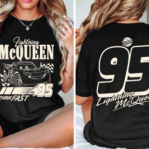 May include: Black t-shirt featuring a graphic of Lightning McQueen with the text "Lightning McQueen" and "95". The front design includes a car illustration and the words "Think Fast". The back displays a large "95" and "Lightning McQueen".
