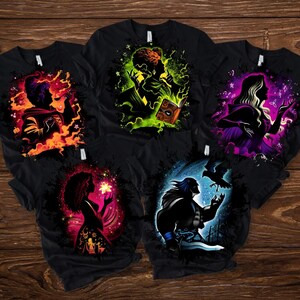 May include: Five black t-shirts with colorful graphic designs. Each shirt features a silhouette of a character surrounded by vibrant hues of orange, green, purple, pink, and blue. The designs appear to be inspired by fantasy or mystical themes.