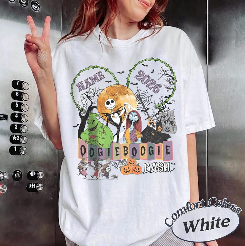 May include: A white t-shirt featuring a graphic print of characters from The Nightmare Before Christmas, including Jack Skellington, Sally, and Oogie Boogie. The design includes a full moon, spiderwebs, pumpkins, and the text NAME 2026 OOGIEBOOGIE BASH.